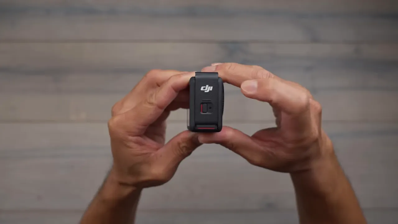 Close-up side view of DJI Osmo Action 6 showing the lockable sliding door and red slider