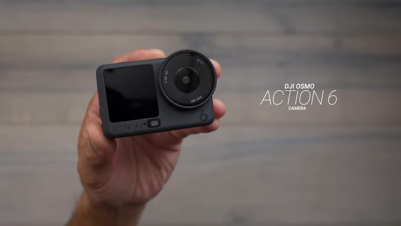 Hand holding a DJI Osmo Action 6 showing the front screen and lens
