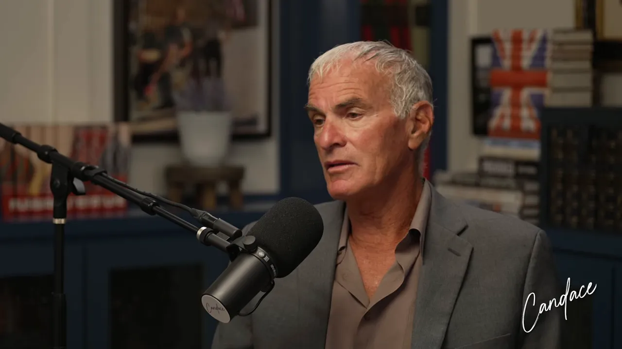 Norman Finkelstein in a solemn, reflective moment during the Candace Owens interview, seated at a podcast microphone
