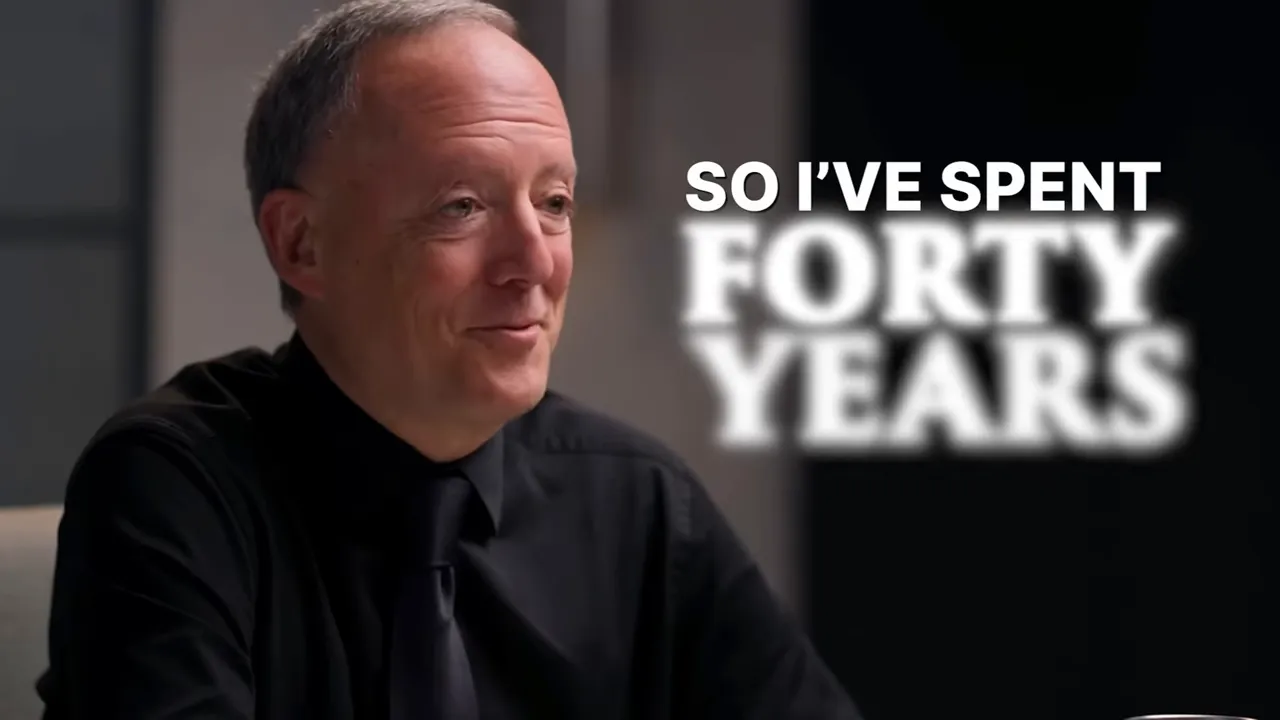 Clear studio interview shot of the guest smiling with on-screen text 'SO I'VE SPENT FORTY YEARS'.