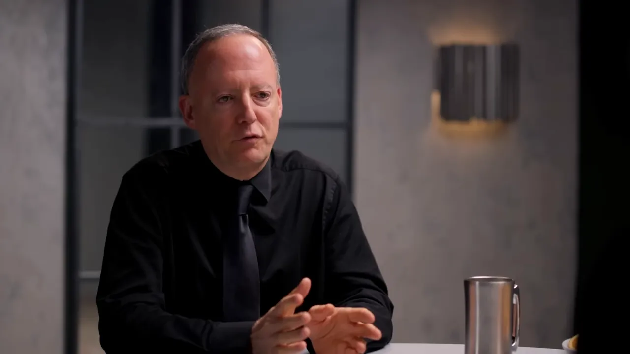 Guest explaining the refeeding protocol with a metal mug and a plate of fruit visible on the table.