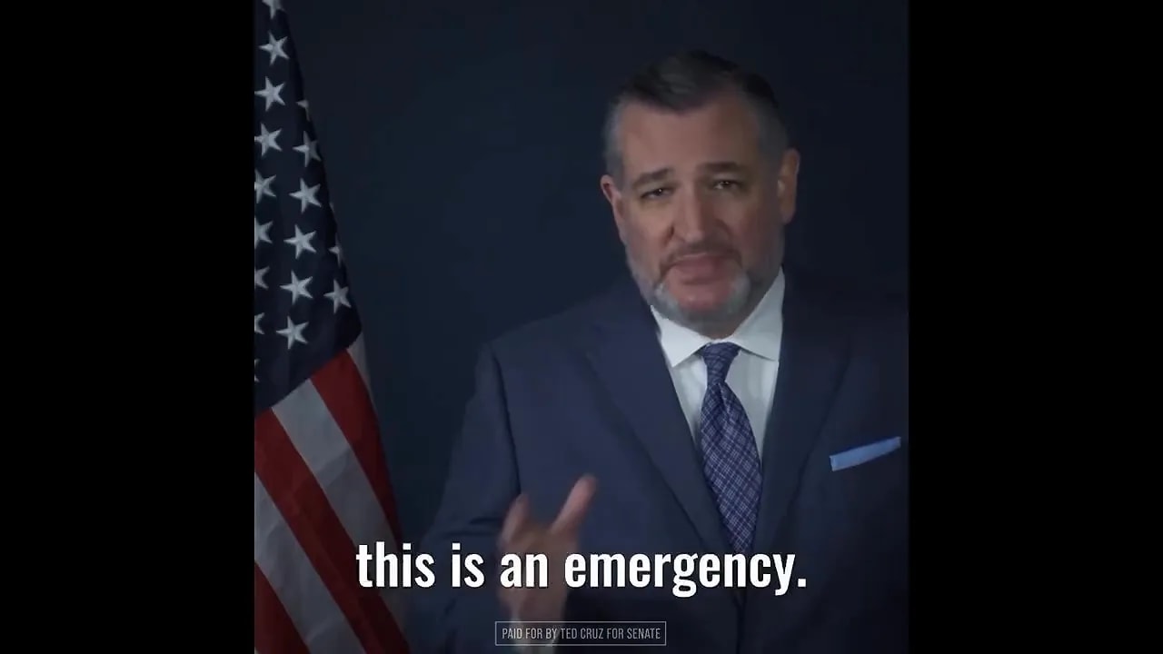 Ted Cruz speaking beside an American flag with on screen text reading this is an emergency