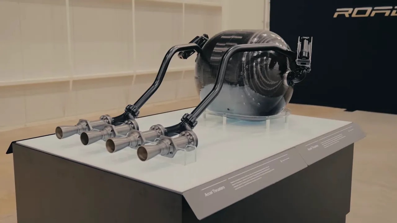 Pressure vessel with attached pipes and nozzle assemblies displayed on a white plinth